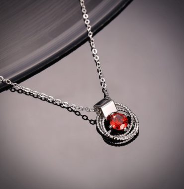 Braid necklace plated with platinum and has a red zircon in the middle