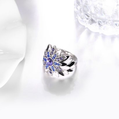 Water drop is a unique ring plated with platinum and inlaid withblue and violet diamond crystals and decorated by black oil drip