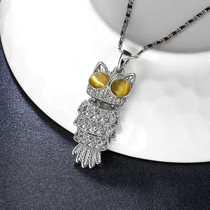 The owl necklace plated with platinum and the eyes are inlaid with brown opals.