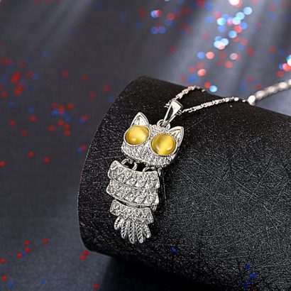 The owl necklace plated with platinum and the eyes are inlaid with brown opals.