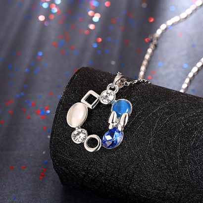 A unique design of combined ornaments plated with platinum, inlaid with white opal, blue glass stone and a crystal diamond