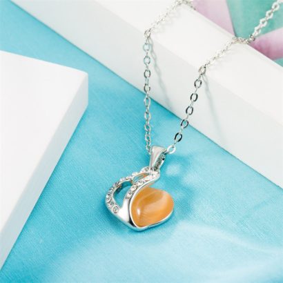 Heart necklace, plated with gold and inlaid with white crystals and an orange opal