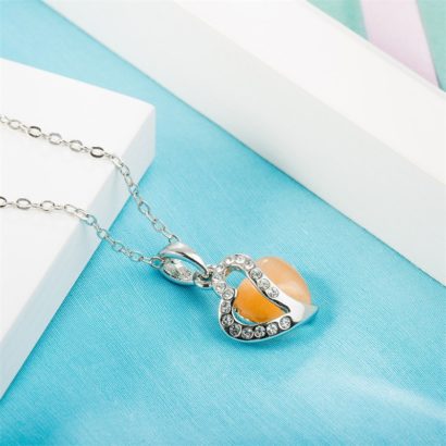 Heart necklace, plated with gold and inlaid with white crystals and an orange opal