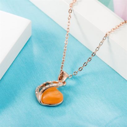 Heart necklace, plated with gold and inlaid with white crystals and an orange opal